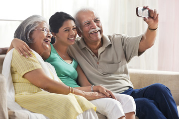 Grandparents and granddaughter taking a photograph of themselves