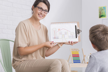 Woman wearing glasses showing drawing to child