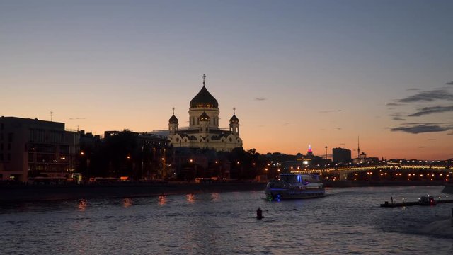 Illuminated Pleasure boat sails across Moscow River at night