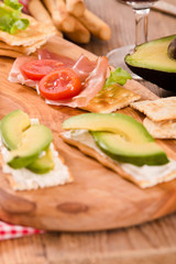 Crackers with ham and avocado. 