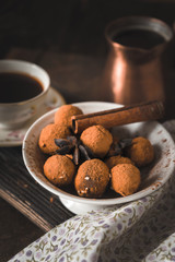Chocolate truffle and coffee on the wooden table vertical