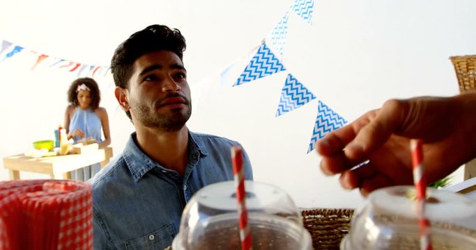 Waiter serving juice to customer