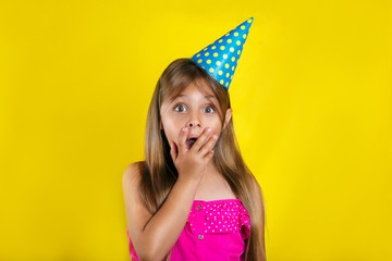 Studio portrait of a little girl wearing a party hat on her birthday