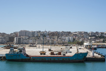 Marocco: una nave nel porto e lo skyline di Tangeri, città marocchina sulla costa del Maghreb all'entrata occidentale dello stretto di Gibilterra, dove il Mar Mediterraneo incontra l'Oceano Atlantico