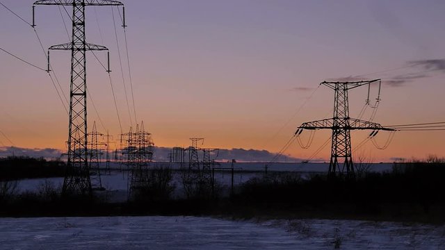 High-voltage power lines at sunrise. Fuel and power generation Timelapse.