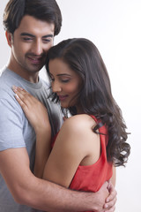 Fototapeta premium Romantic young couple embracing against white background