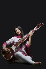 Obraz premium Young woman playing the sitar