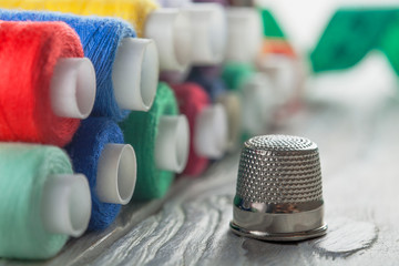 colored sewing thread and bobbin on a wooden background