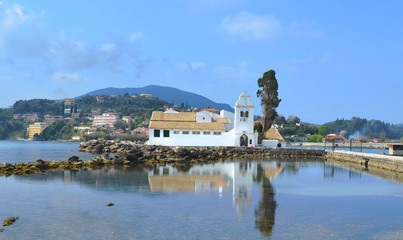Fototapeta na wymiar Sur l'ilot du même nom , le monastère de Panagia ton Vlachernon à Corfou se reflétant dans la mer Méditerranée 