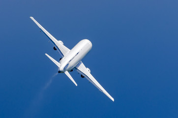 White airplane takes off in the rain in the blue sky
