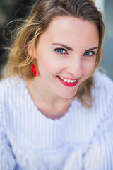 Naklejka premium Portrait of young smiling woman with blue eyes who is outdoors