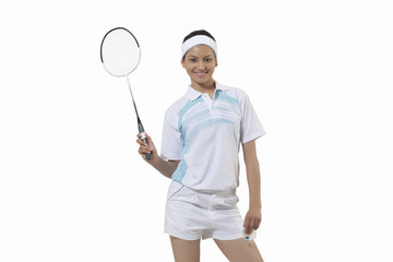 Portrait of young woman holding badminton racket and shuttlecock isolated over gray background