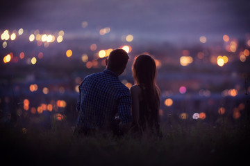 Lovers man and girl against background night city, night starry sky and horizon. Concept date...