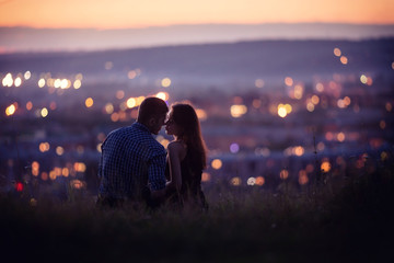 Lovers man and girl against background night city, night starry sky and horizon. Concept date...