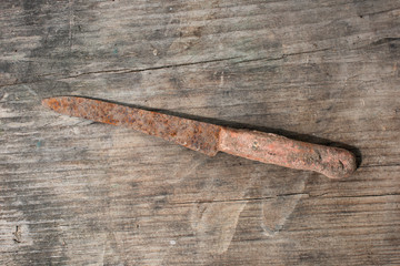 Ancient rusty knife on a wooden background
