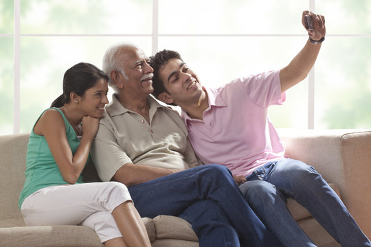 Grandfather and grandchildren taking a photograph of themselves
