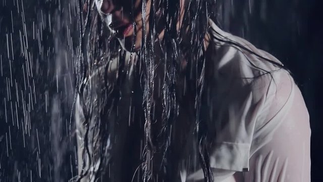 close-up. wet sexy girl with big silicone Breasts in a white unbuttoned shirt. she is upset and catches drops by hand