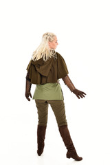 Fototapeta premium full length portrait of a blonde girl wearing green and brown medieval costume, holding a bow and arrow. isolated on white background.