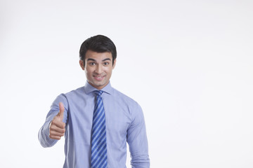 Portrait of a male executive giving thumbs up