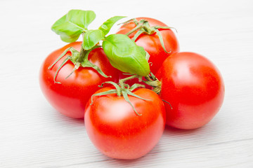 group of fresh resd tomatoes with basil