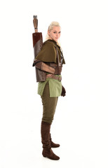 full length portrait of a blonde girl wearing green and brown medieval costume, holding a bow and...