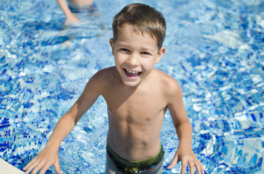 Cute laughing boy in the swimming pool. Summer vocation
