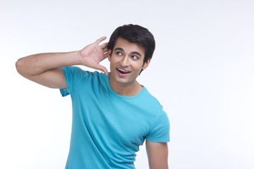 Surprised young man listening carefully isolated over white background
