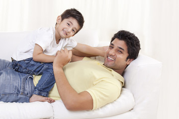 Fototapeta premium Portrait of father and child on sofa 
