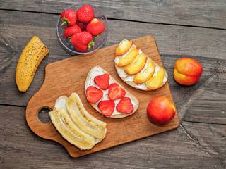 Healthy breakfast toasts. Wholegrain bread slices with cream cheese, various fruit,  Top view,  Clean eating, vegetarian, dieting concept