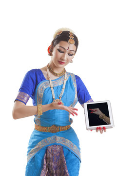 Bharatanatyam dancer showing Kangula Hasta mudra on digital tablet over white background