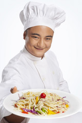 Portrait of chef with plate of noodles