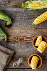 Organic farm food. Cutted corn cobs on rustic wooden background top view copyspace