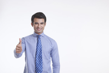 Portrait of a male executive giving thumbs up