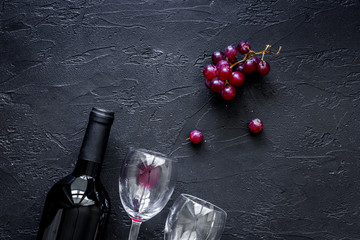Wine glasses and bottle on black stone table background top view copyspace