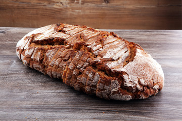 freshly baked bread on wooden board. cutted bread