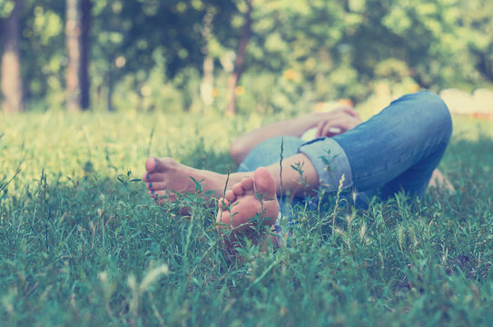 A young girl lying on the grass in the Park and resting. Concept, outdoor recreation, serenity