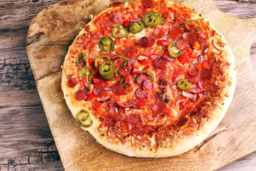 Hot pizza slice with melting cheese on a rustic wooden table. Italien food concept