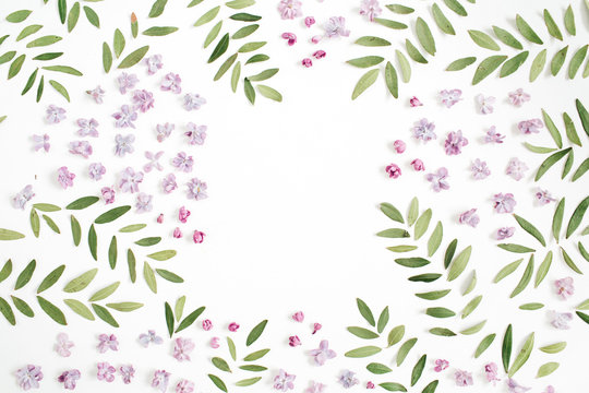 Frame of lilac flower petals, green leaves with space for text on white background. Flat lay, top view