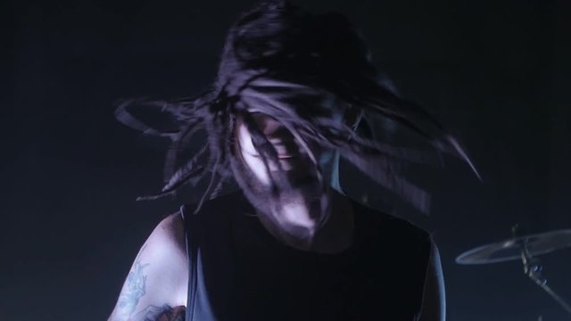 man with dreadlocks waving his head. Dreads rotate in slow motion