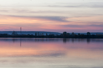 Field, river and beautiful sky and clouds reflected