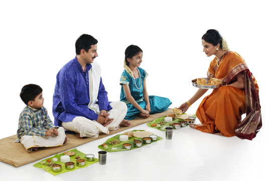 South Indian woman serving food to her family 