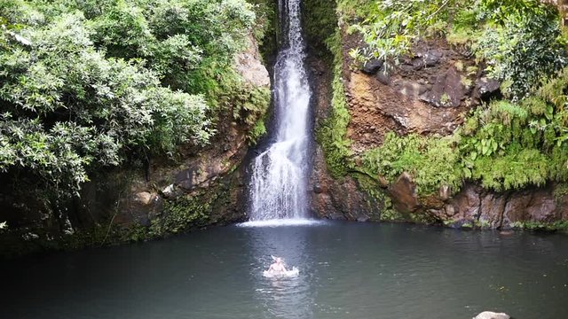 Man swims near senic Mauritius watefall