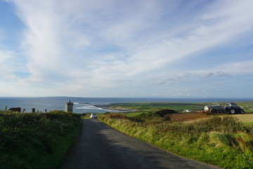 An old road leading to a castle by the coast of Atlantic Ocean, Ireland