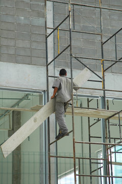 construction worker on scaffolding without harness or protective gear