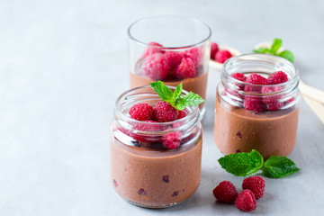 Chocolate mousse with fresh raspberry and mint in a glass jar