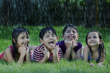 Happy boys and girls catching raindrops on tongue 