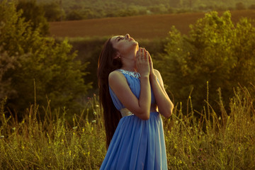 Girl praying at sunset