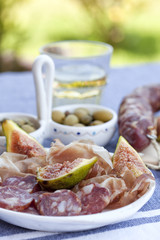 traditional mediterranian meat appetizers with olives, figs and white wine