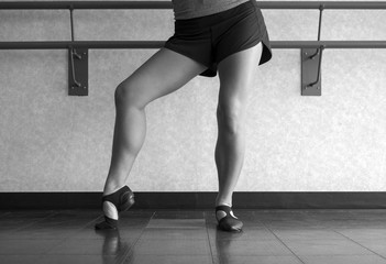 Black and white version of Posing in Jazz shoes at the barre in dance class