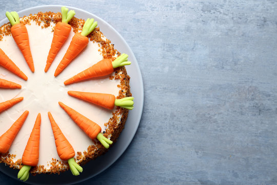 Plate with delicious carrot cake on grey table
